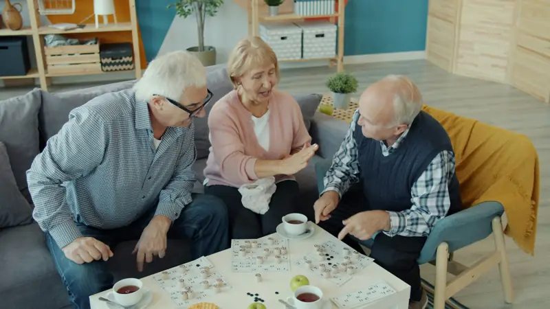 Seniori spolu hrajú loto pri čaji